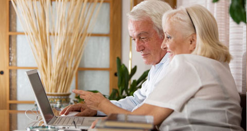 An elderly couple using a laptop
